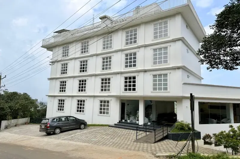 White multi-story building exterior and entrance of Vanaheim Resort in Vagamon