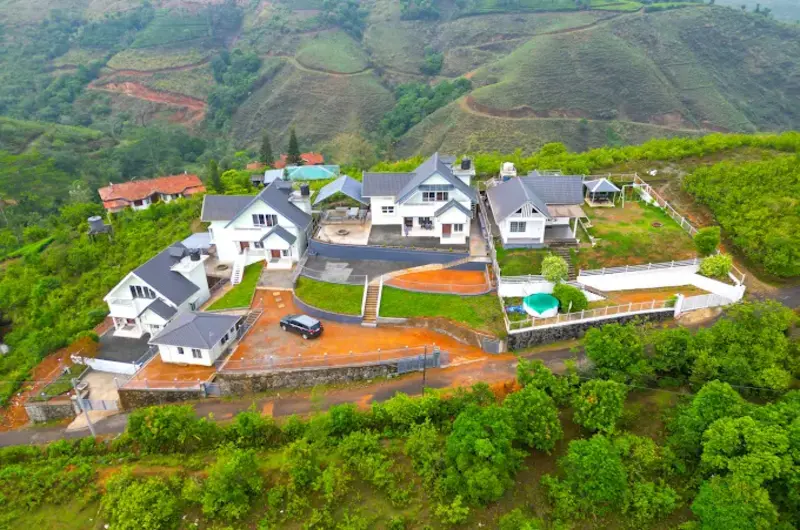 Aerial view of Nexstay Mount Tales resort surrounded by green hills in Vagamon Kerala