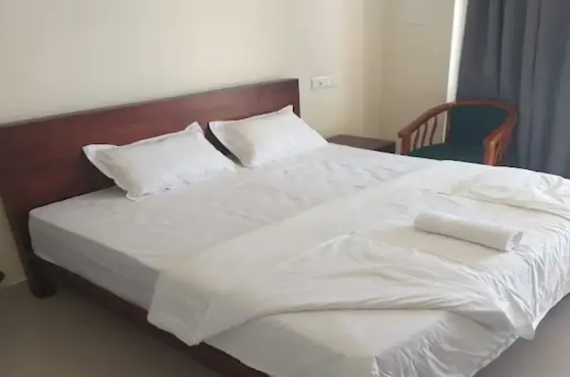 Modern luxury resort bedroom featuring large windows overlooking Vagamon hills