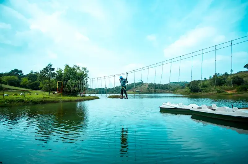 Scenic lake view surrounded by lush green hills near Nexstay Mount Tales Vagamon