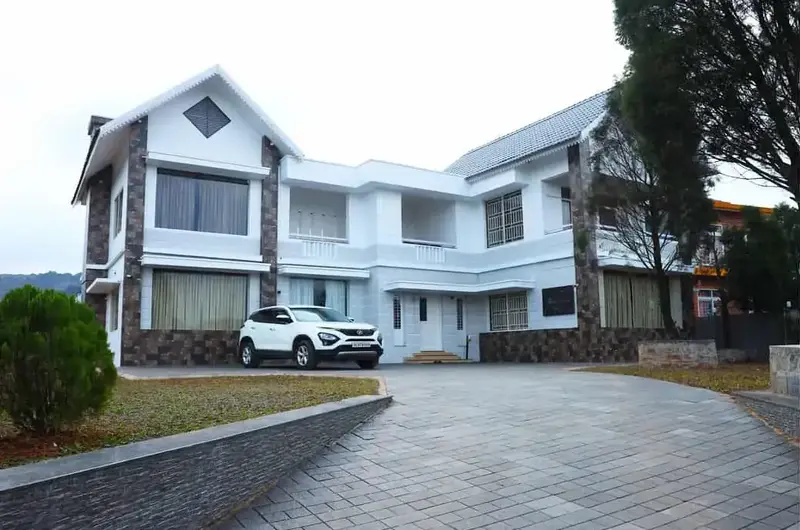 Exterior view of Mountain Mist Resort building with paved driveway in Vagamon
