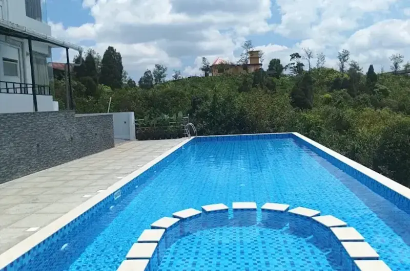Infinity swimming pool overlooking scenic green mountains at Mountain Mist Resort Vagamon