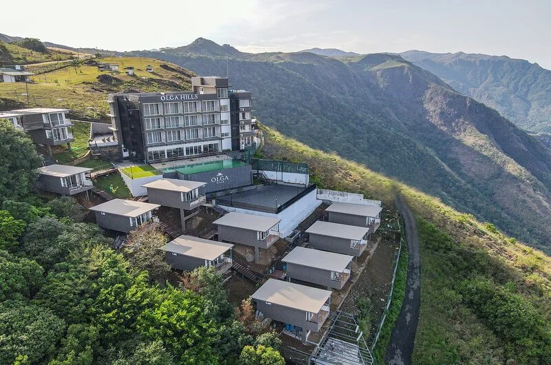 Panoramic hillside view of Olga Resorts surrounded by lush valley scenery in Vagamon Kerala
