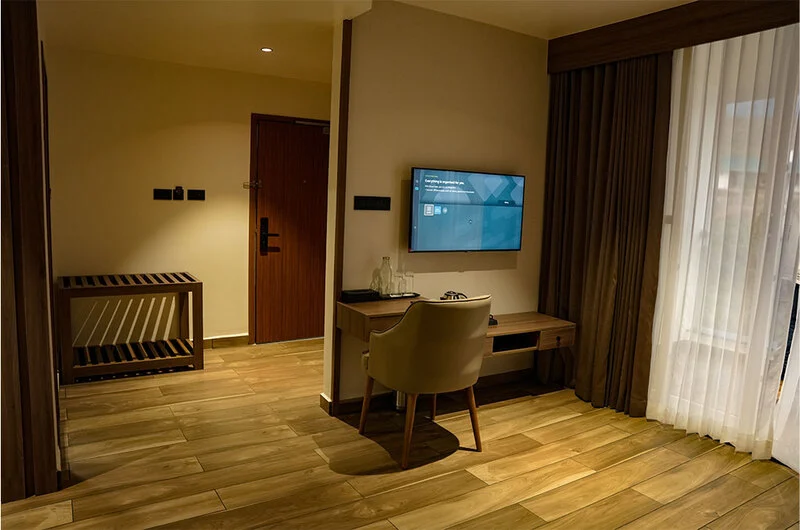 Comfortable deluxe guest bedroom suite with wall-mounted TV at Olga Resorts Vagamon
