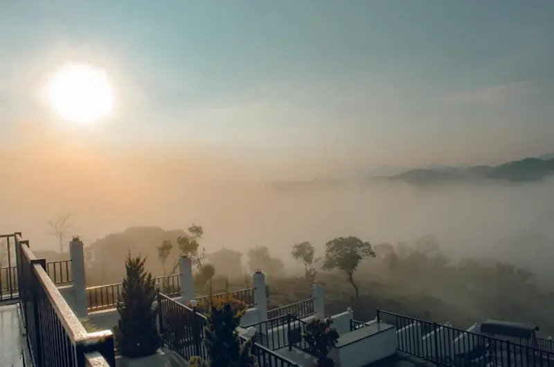 Scenic misty morning view of hills and trees from a balcony at ODMOR Resort Vagamon