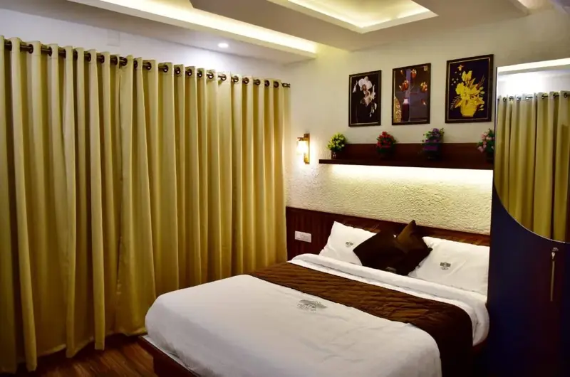 Cozy resort bedroom with double bed, ambient headboard lighting, and elegant drapes at ODMOR Resort Vagamon