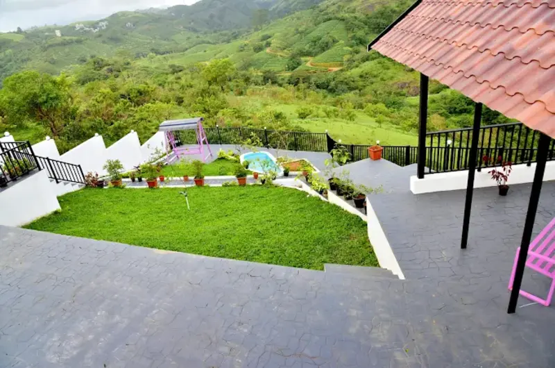 Landscaped green lawn and outdoor courtyard with hill views at ODMOR Resort Vagamon