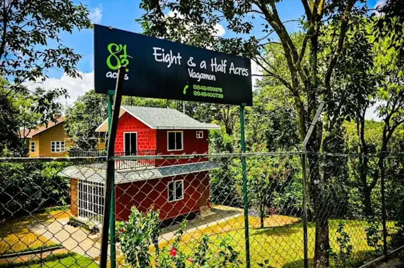 Wooden cabin cottage surrounded by lush greenery at 8.5 Acres Vagamon
