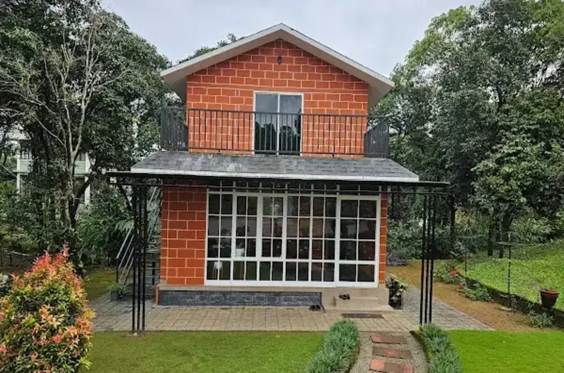 Two-story red wooden chalet building at 8.5 Acres resort Vagamon