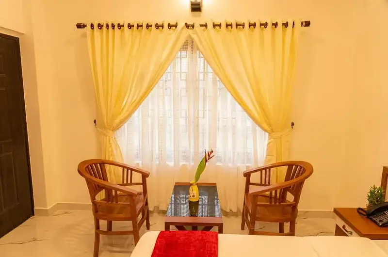 Cozy in-room seating area with wicker chairs and soft lighting at Vagamon Vagashore resort