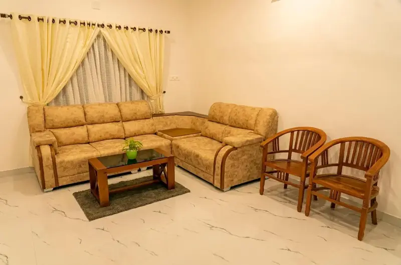Spacious guest living room with plush sectional sofa and elegant decor at Vagamon Vagashore resort