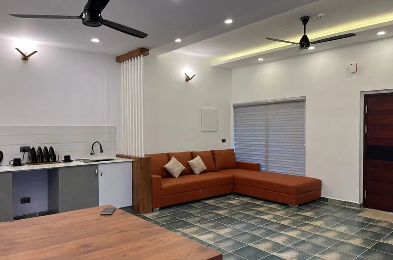Open-plan studio cottage interior with living seating area, dining space, and kitchenette at Willow House Cottages