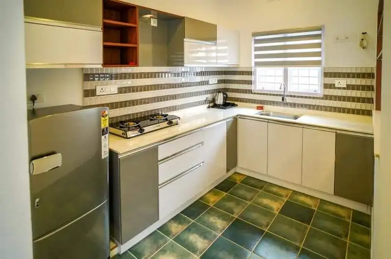 Modern fully equipped kitchenette with counter space and refrigerator at Willow House Cottages