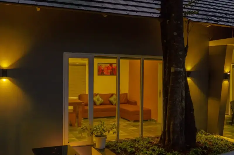 Exterior glass window view showcasing warm indoor lighting and cozy cottage ambience at Willow House Cottages