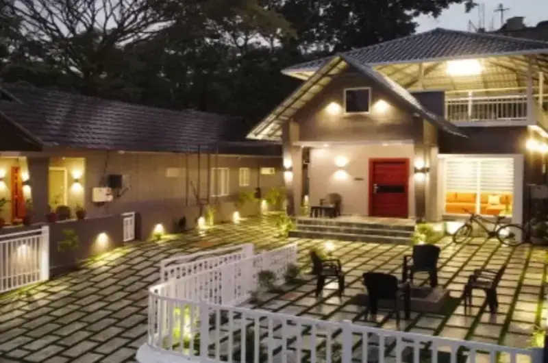 Exterior view of Willow House Cottages illuminated at night with warm outdoor lighting in Vagamon
