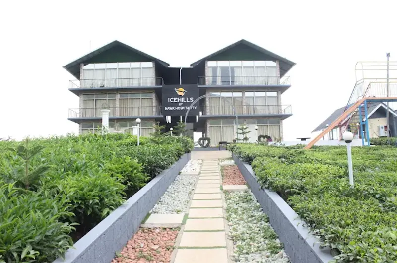 Front facade of Ice Hills Resort with stone walkway and landscaped garden lawns