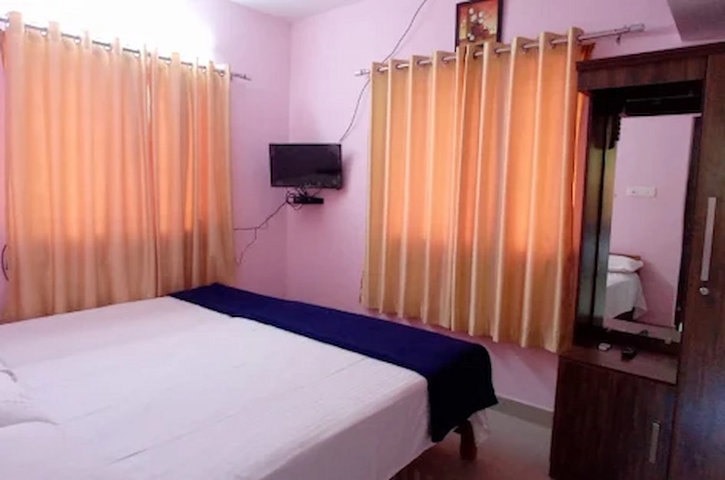 Standard guest bedroom featuring warm ambient lighting and wardrobe at Vaga View Residency