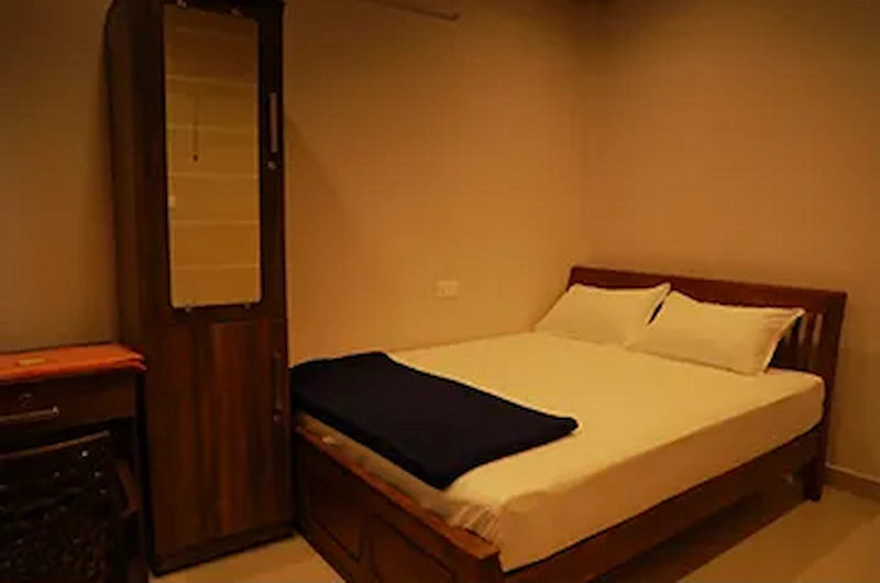 Comfortable double bedroom suite with wooden wardrobe at Vaga View Residency