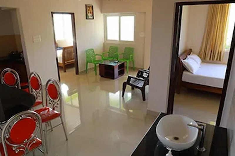 Spacious guest suite interior with bedroom and seating space at Vaga View Residency