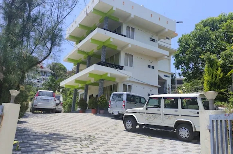 Exterior view of Vaga View Residency building with parking area in Vagamon