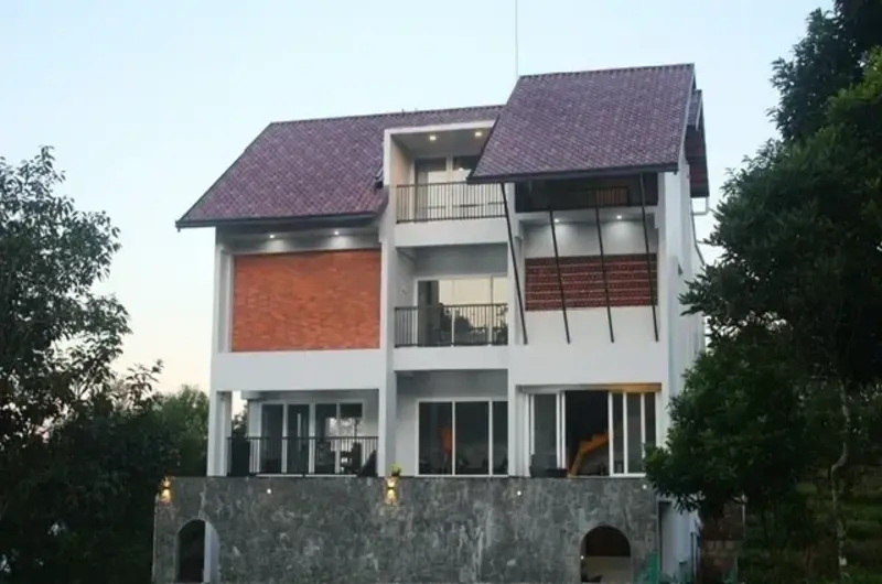 Multi-level resort villa cottage set against a scenic hillside at Vagamon Exotica