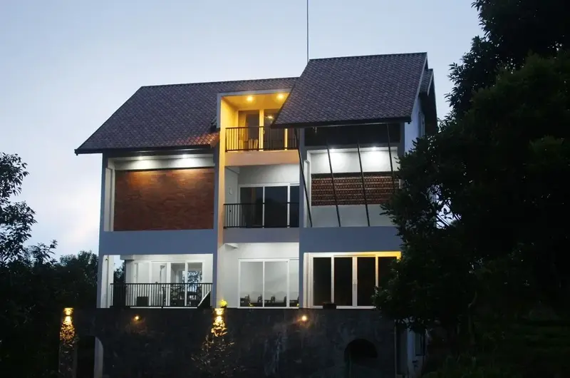 Modern resort building exterior brightly illuminated at night at Vagamon Exotica