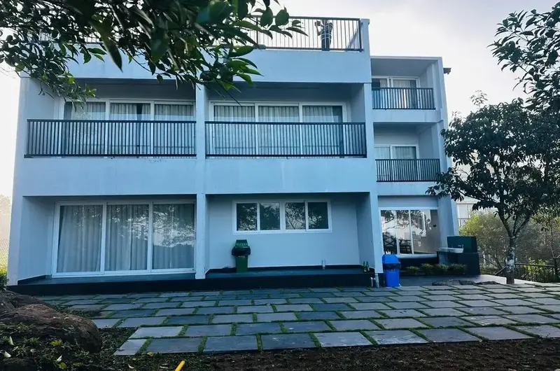 Front facade of modern multi-story villa with glass balconies at Vagamon Exotica