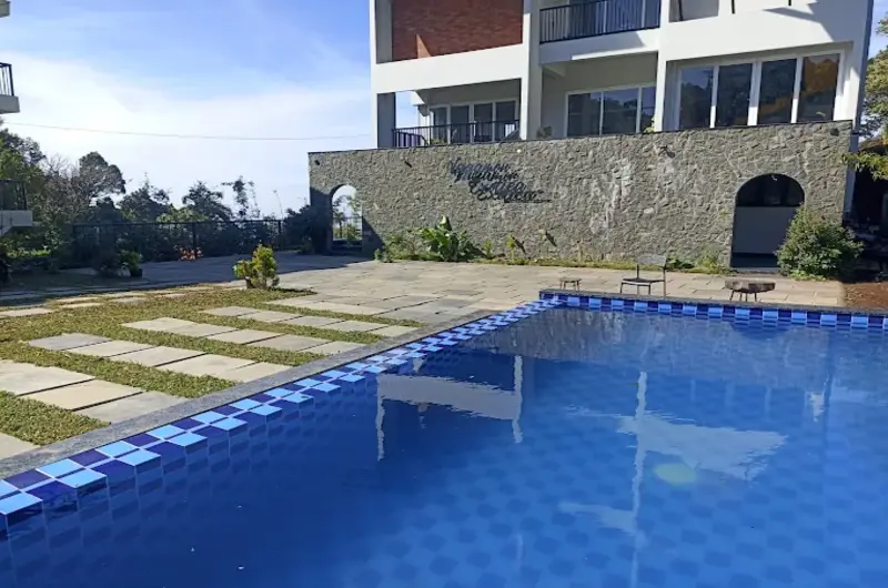 Outdoor swimming pool area with paved deck and scenic mountain backdrop at Vagamon Exotica
