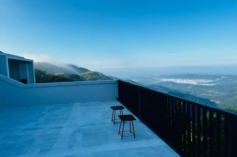 Scenic open terrace lounge overlooking mountain views and misty horizon at Vagamon Exotica