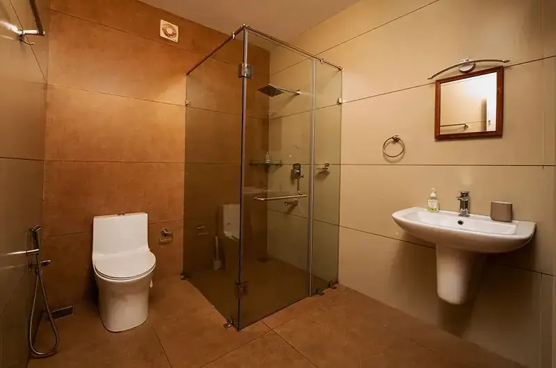 Modern en-suite bathroom with glass shower enclosure and sleek vanity fixtures at Ghats Edge