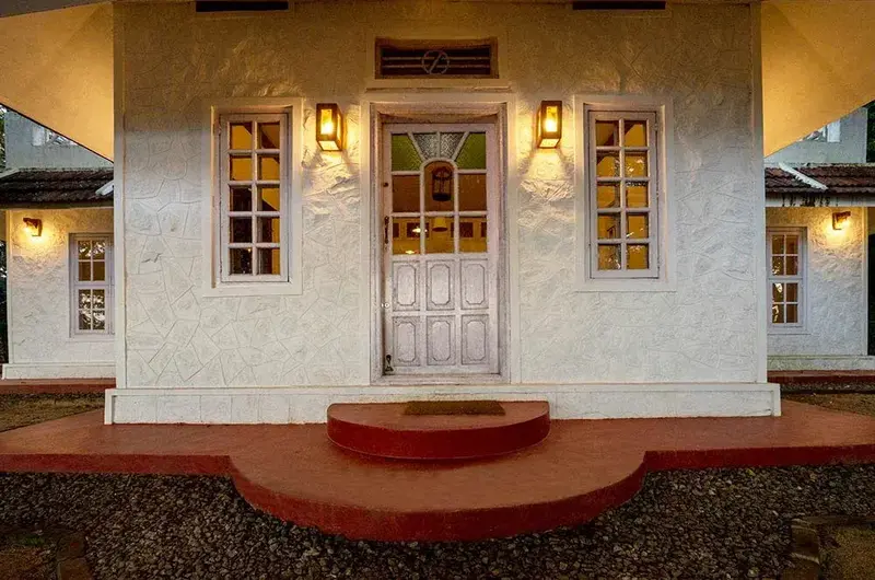 Traditional villa entrance and porch illuminated at twilight at Ghats Edge