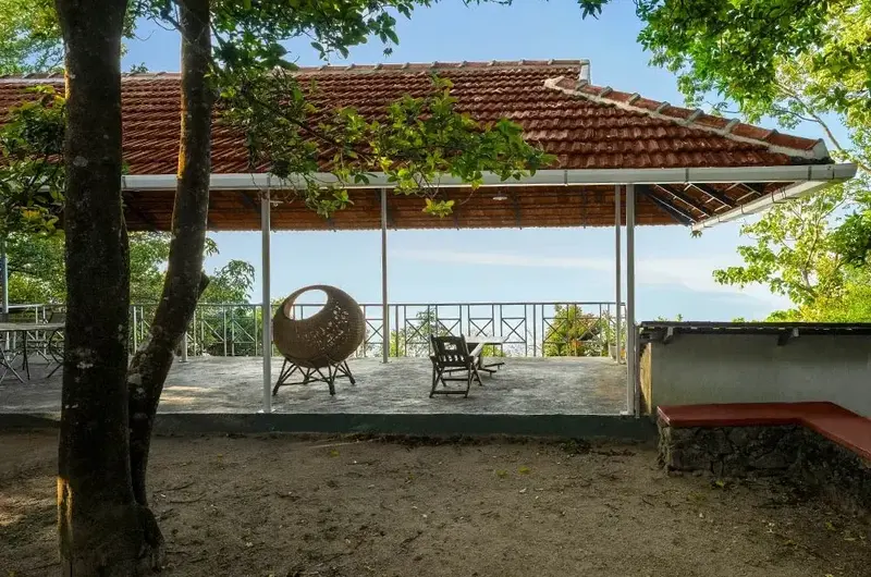 Open gazebo sitting area overlooking lush forest landscape at Ghats Edge