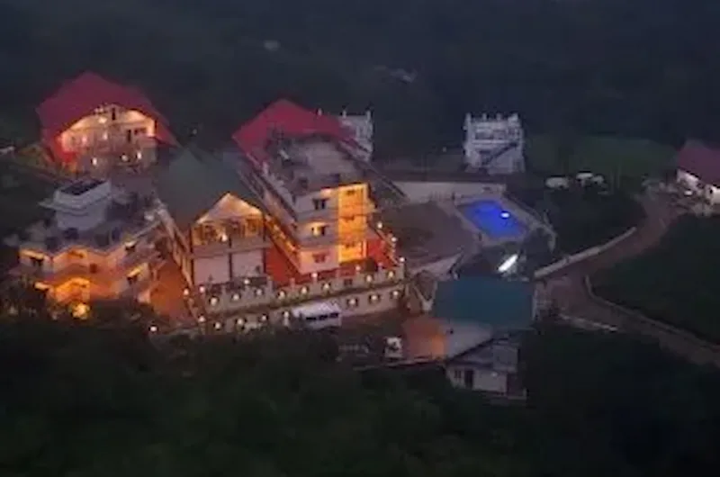 Illuminated night view of Pine Clough Resort building in Vagamon