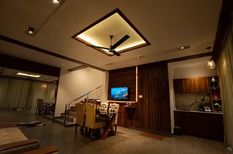Cozy deluxe bedroom with modern wooden false ceiling at Golden Meadows Resort