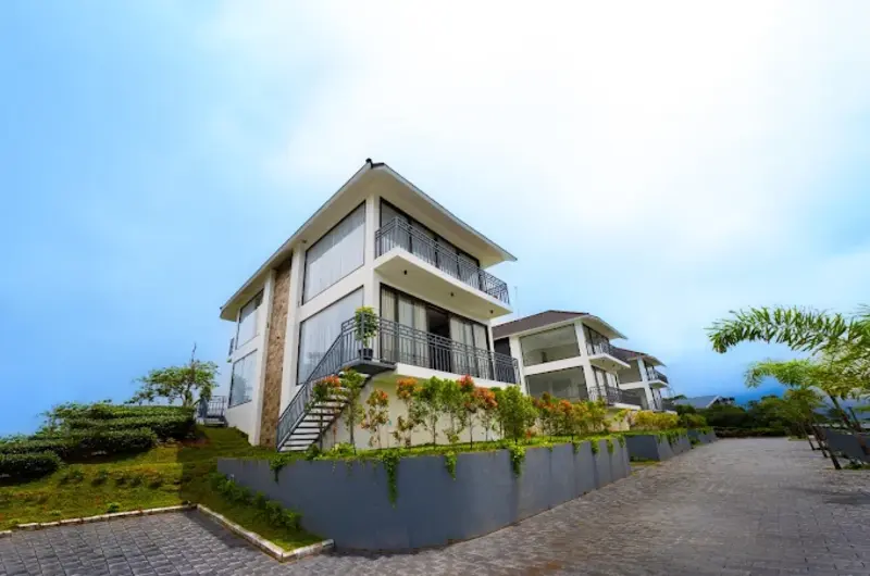 Modern multi-story cottage building with balconies at Golden Meadows Resort Vagamon
