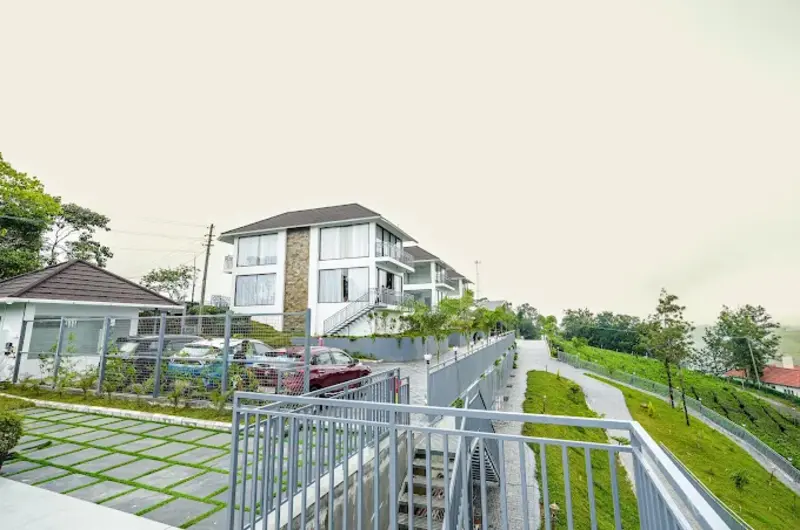 Exterior view of Golden Meadows Resort with manicured green lawns in Vagamon
