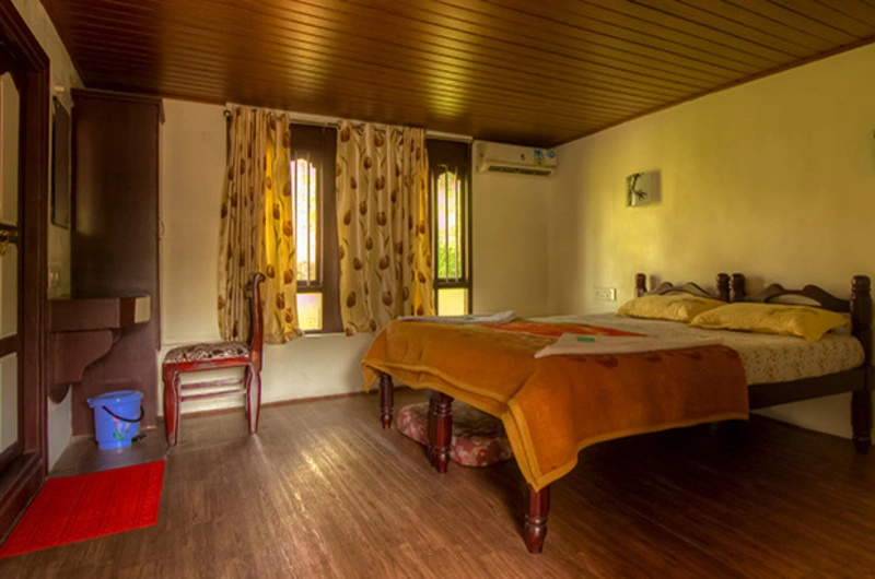 Warmly lit bedroom with wooden ceiling paneling at Vaga Nakshathra Suites