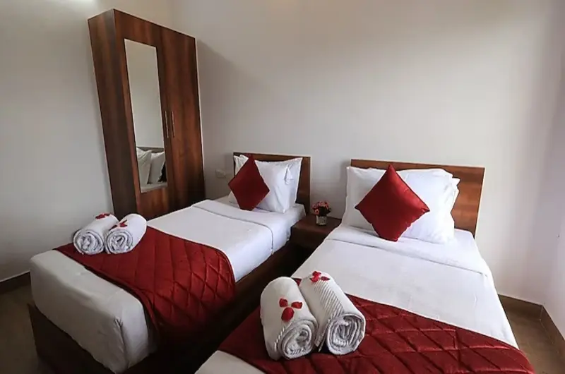 Twin bed room setup with clean white linens at Vagamon Hill Chimes resort