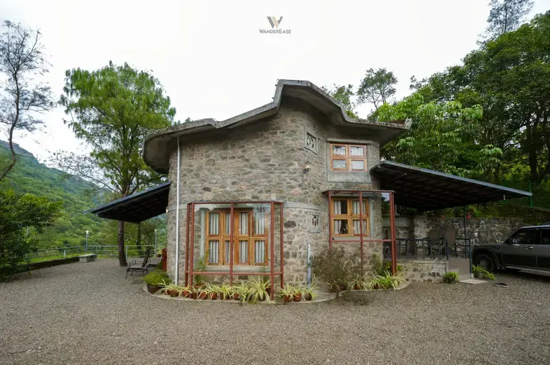 Traditional stone cottage façade nestled in greenery at Stone Haven by Wanderease Vagamon