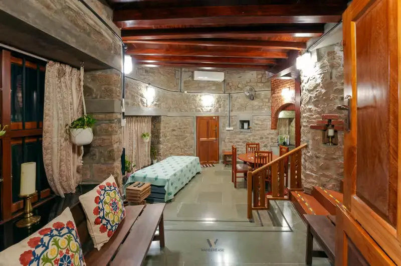 Spacious rustic living room with exposed stone walls and wooden furnishings at Stone Haven by Wanderease