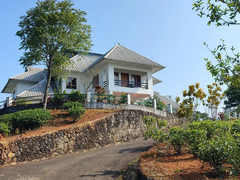 Exterior view of Zen Garden Wellness Homestay surrounded by green lawn in Vagamon Kerala