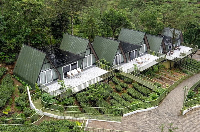 A-frame cottages and luxury accommodations nestled among green mountain slopes in Vagamon