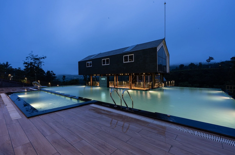 Santuario Resort outdoor swimming pool with luxury stays at dusk in Vagamon