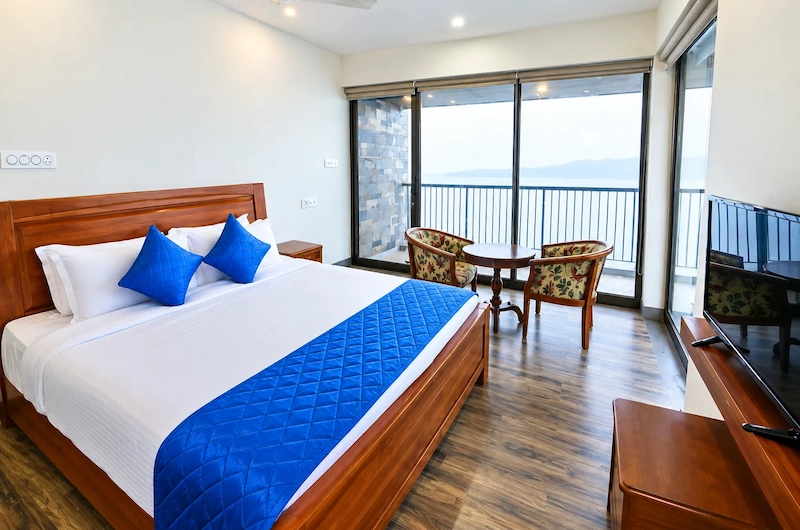 Deluxe bedroom interior featuring blue runner bedding and adjacent seating area in Vagamon