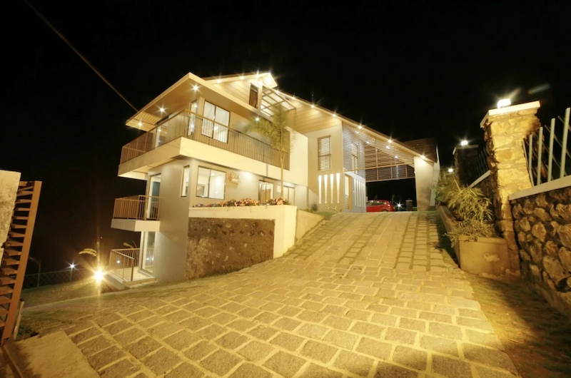 Illuminated night view of Honeycomb resort property on a paved hillside slope