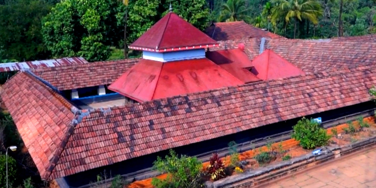 Aerial view of historic Thirunelli Temple surrounded by lush green forests in Wayanad