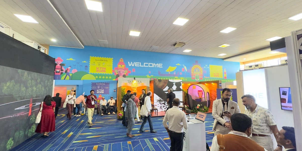Visitors exploring digital tourism pavilion with promotional banners at Kerala Travel Mart