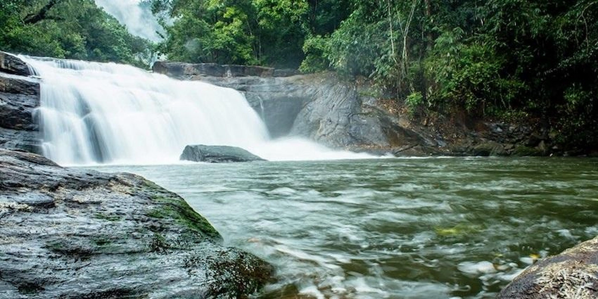 Monsoon waterfall cascading over rocks in lush forest near Chottupara Vagamon Kerala