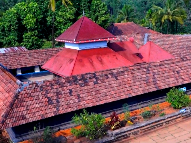 Traditional red tiled roof structure of Thirunelli Temple nestled in Wayanad hills
