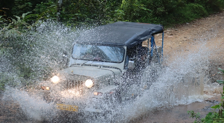 Off-road jeep safari splashing through water in Vagamon during monsoon